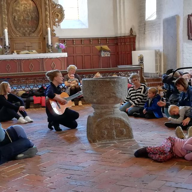 Tine Antonsen spiller guitar for familier i kirken