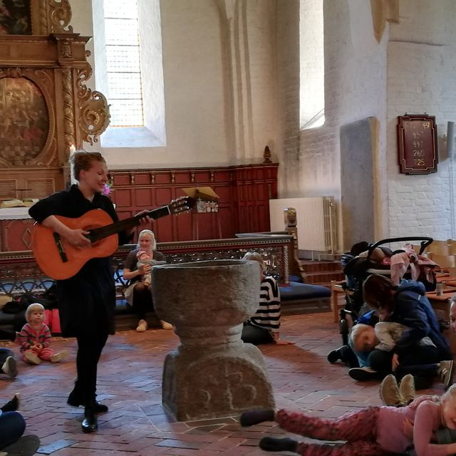 Tine Antonsen spiller guitar for familier i Kirken